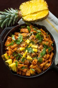 a skillet filled with pasta and pineapple