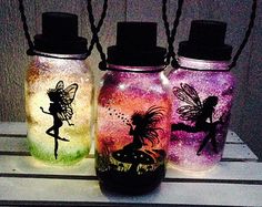 three glass jars with fairy images painted on them