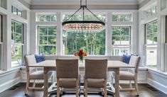 a dinning room table with chairs and a chandelier hanging from the ceiling