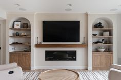 a large flat screen tv mounted on the wall above a fireplace in a living room