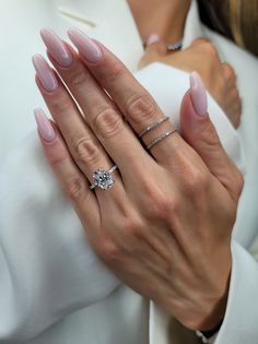 a close up of a person's hands with two rings on their fingers and one ring in the other hand