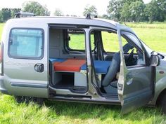 a small van with its door open in the grass