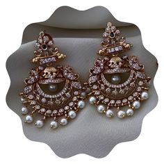 Elevate your look with our stunning Gold Plated Pearl Jhumka Earring Set, a masterpiece of traditional Indian jewelry design. Adorned with radiant Kemp stones and pearls, these handcrafted earrings offer a touch of timeless elegance for any occasion. Perfect for weddings, festivals, or casual outings, this set includes both Jhumka and Chandbali-style earrings, providing versatility and beauty in one package. Features: 💎Gold Plated Finish: The earrings are plated with high-quality gold, offering Luxury Jeweled Temple Jewelry Jhumkas, Luxury Traditional Yellow Gold Jhumkas, Luxury Chandbalis With Tilla For Festivals, Antique Kundan Earrings, Luxury Kundan Earrings For Party, Affordable Chandbali Chandelier Earrings For Festivals, Luxury Diamond Hand Set Jhumkas, Luxury Party Jhumkas With Meenakari, Luxury Jeweled Kundan Jhumkas