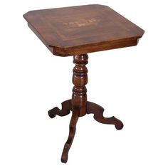 a small wooden table with an ornate design on it's top and legs,