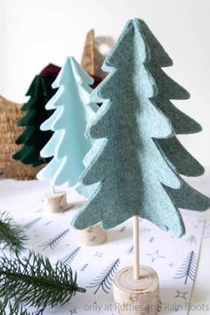 three felt christmas trees sitting on top of a table