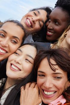 a group of young women standing next to each other with their arms around each other