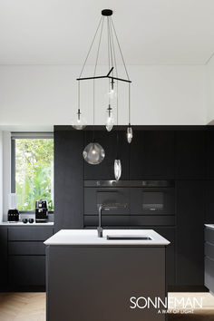 a modern kitchen with black cabinets and white counter tops is featured in the magazine sonnenman