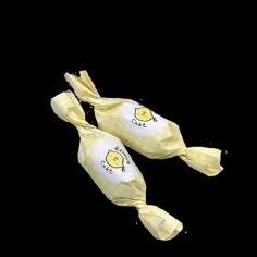 two yellow and white candy bags with lemons printed on the top, tied together