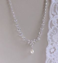 "'Denise' Crystal Bridal Necklace has been created in a sparkling leafy design using marquise shaped cubic zircon crystals. This gorgeous and flattering necklace is completed by a band of crystals graduating to shiny rhodium links for a comfortable and very wearable accessory. The Swarovski teardrop pearl droplet can be customized from our extensive pearl collection, for a truly unique bridal accessory. 💜Also available with a crystal teardrop as in photo #4. This listing is for the necklace ONL Exquisite Marquise Wedding Necklace, Wedding Marquise Cut Diamond White Necklace, Marquise Cut Diamond White Necklace For Wedding, Dazzling Marquise Wedding Necklace, Delicate Marquise Wedding Necklaces, Delicate Marquise Necklace For Wedding, Marquise Necklace, Coordinates Jewelry, Necklace With Pearl