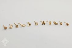 five pairs of gold earrings on a white background with the word love spelled in small letters