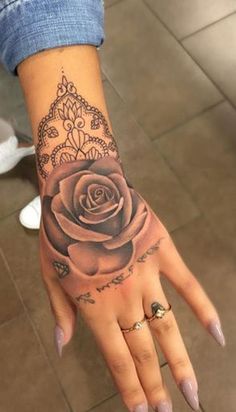 a woman's hand with a rose tattooed on the middle of her left arm