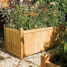 a wooden planter filled with lots of flowers