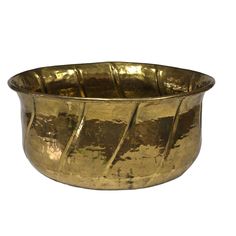 a brass bowl with wavy lines on the rim