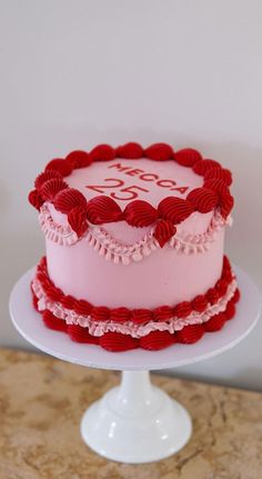 a pink and red cake on a white plate