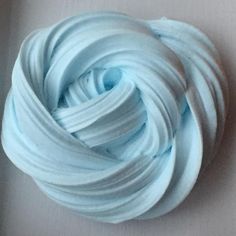 a ball of blue yarn sitting on top of a white tablecloth covered in frosting