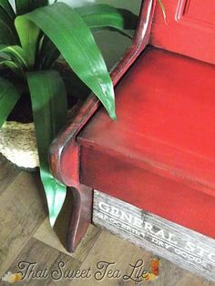 a red chair sitting next to a potted plant