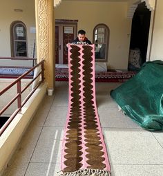 a man standing in front of a large carpet on the floor