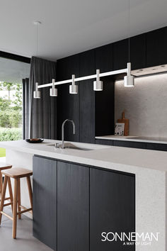 a modern kitchen with black cabinets and white countertops is featured in the magazine sonnenman