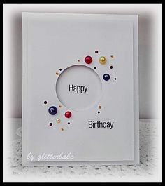 a birthday card with pearls and confetti around the circle on it, saying happy birthday