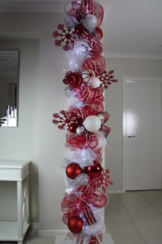 a tall christmas tree decorated with red and white ornaments