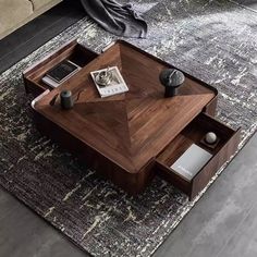 a living room with a coffee table and rugs on the floor in front of it