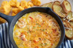 an omelet with shrimp and cheese in a cast iron skillet next to bread