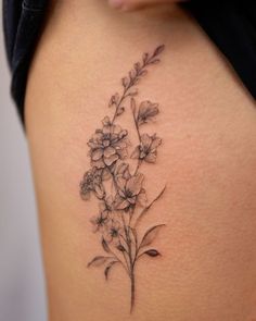 a woman's thigh with flowers on it and the bottom part of her stomach