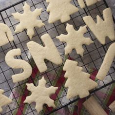 some cookies that are sitting on a cooling rack with the word snow spelled in them