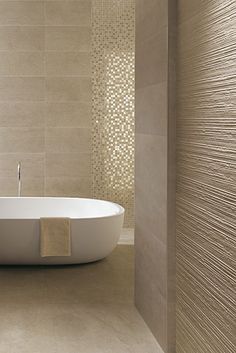 a white bath tub sitting inside of a bathroom next to a wall mounted faucet