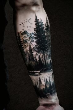 a man's arm with trees and birds on it