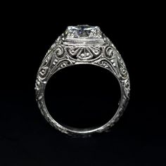 an antique style diamond engagement ring with filigrees