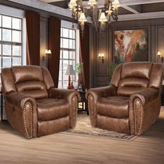 two brown recliners sitting next to each other in front of a chandelier