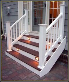 a white porch with stairs and lights on it