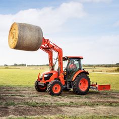 a tractor with a large bale of hay on it's back in a field