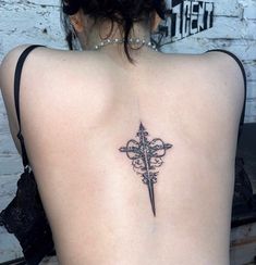 a cross tattoo on the back of a woman