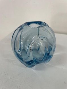 a blue glass vase sitting on top of a white table