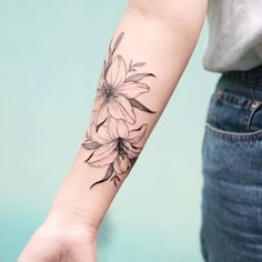 a woman's arm with a flower tattoo on it