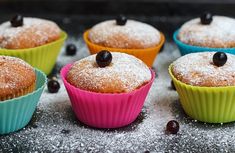 several cupcakes with blueberries and powdered sugar on top are lined up