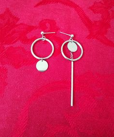 A retro feel in a modern look. Both earrings hold a large circle. In one earring, a smaller disc hangs from the circle.  In the other earring, the disc is suspended within the circle. A long bar emerges from behind and dangles down. A cool and unique addition to your look. CUSTOMIZATION: Convert to screw back clip-on earrings by request. Add request as message to order. Check out more earrings at: impulsenotionjewelry.etsy.com Earrings Circle, Kpop Kdrama, Mismatched Earrings, Bar Earrings, Wire Earrings, Single Earring, Star Earrings, Earring Backs, Tassel Earrings