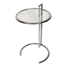 a glass and chrome side table with a metal frame on the bottom, against a white background