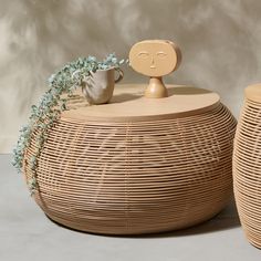 two wicker baskets with faces on them and one has a plant growing out of it