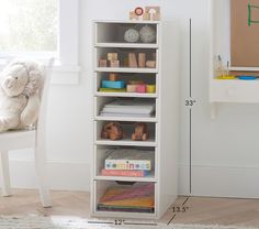 a white book shelf sitting next to a window with a stuffed animal on top of it