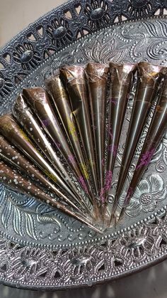 a silver tray with five different types of chocolates on it, and one is in the shape of a fan