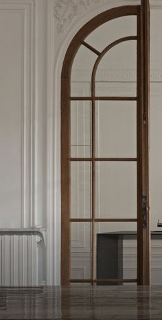 an open door in a white room with wooden floors