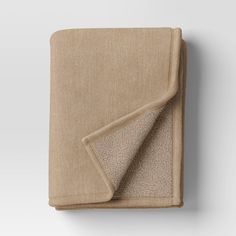 an image of a blanket folded on top of each other with a beige color scheme