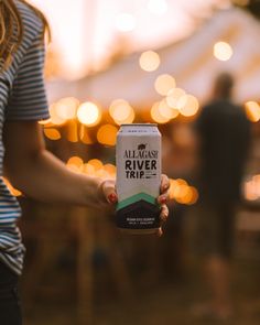 a woman holding up a can of beer