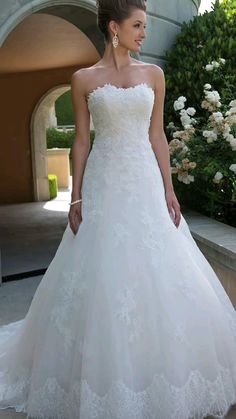 a woman in a wedding dress standing outside