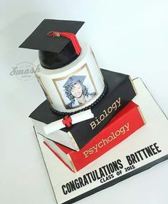 a cake made to look like books with a graduation cap and diploma on top that reads,