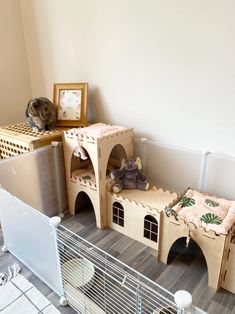 a cat house made out of cardboard and stuffed animals on the floor next to it