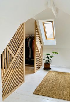 an open door leading to a bedroom with a plant in the foreground and a skylight above it